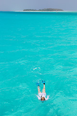 Image showing Woman snorkeling in clear shallow sea of tropical lagoon with turquoise blue water.