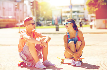 Image showing teenage couple with skateboards on city street