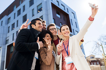 Image showing happy people with conference badges taking selfie