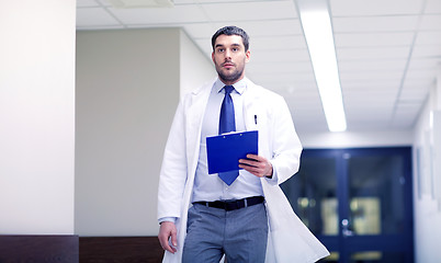 Image showing doctor with clipboard walking along hospital