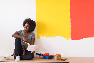 Image showing back female painter sitting on floor