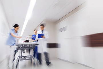 Image showing medics and patient on hospital gurney at emergency