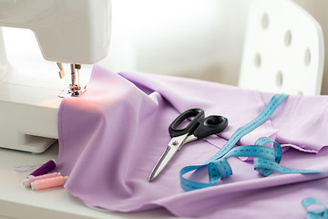 Image showing sewing machine, scissors, tape measure and fabric