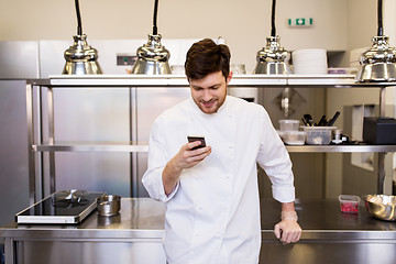 Image showing chef cook with smartphone at restaurant kitchen