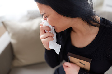 Image showing crying woman with photo frame at funeral day