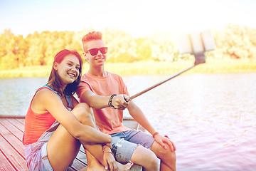 Image showing happy teenage couple taking selfie on smartphone