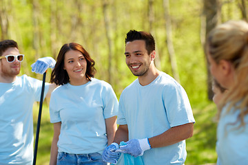 Image showing volunteers with garbage bags cleaning park area