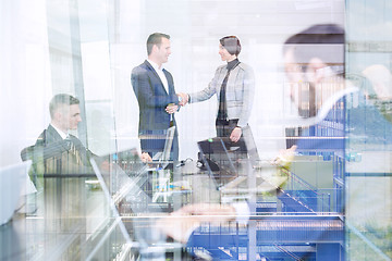 Image showing Business people shaking hands in moder corporate office.