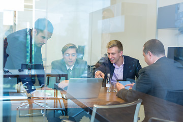 Image showing Relaxed cheerful business people sitting and talking at corporate meeting.