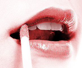 Image showing Girl Applying Red Lip Gloss To Her Lips