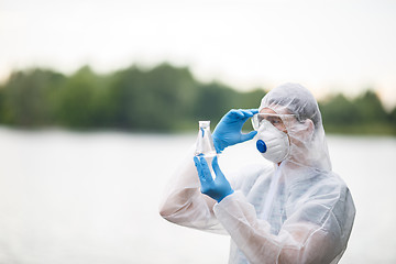 Image showing Chemist holds flask with water