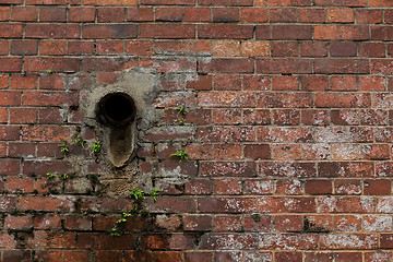 Image showing Old red brick wall with pipe