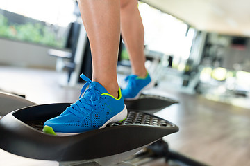 Image showing Woman working out on elliptical trainer in gym