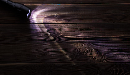 Image showing Wooden background with glowing flashlight