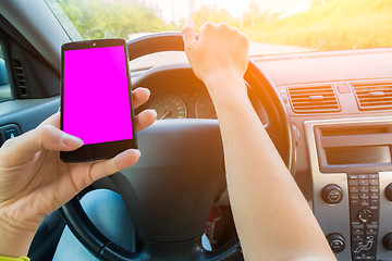 Image showing Girl holding smartphone in car