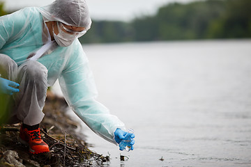 Image showing Ecologist takes water for examination