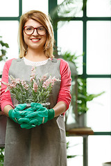 Image showing Young florist in rubber gloves