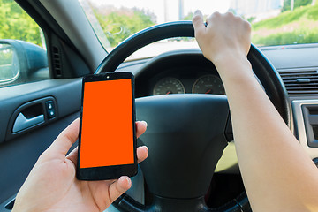 Image showing Driver holding smartphone in car