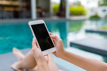 Image showing Young Woman using mobile phone in swimming pool