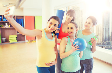 Image showing pregnant women taking selfie by smartphone in gym