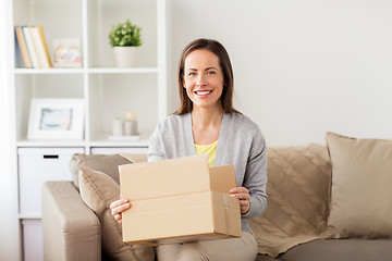 Image showing smiling woman opening cardboard box