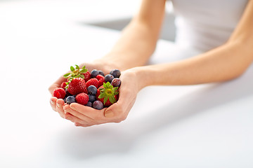 Image showing close up of young woman hands holding berries