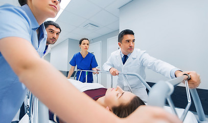 Image showing medics with woman on hospital gurney at emergency