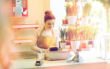 Image showing florist woman at flower shop cashbox on counter