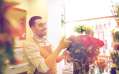 Image showing smiling florist man with roses at flower shop