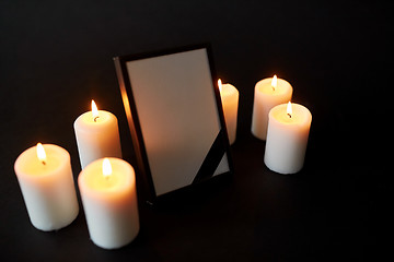 Image showing photo frame with black mourning ribbon and candles