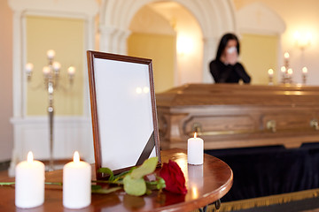 Image showing photo frame and woman crying at coffin at funeral