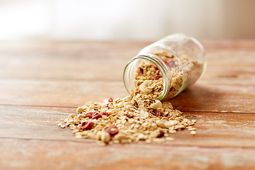 Image showing jar with granola or muesli poured on table