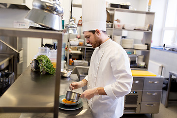 Image showing chef with pot cooking and serving food at kitchen