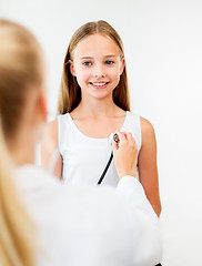 Image showing doctor with stethoscope and girl at hospital