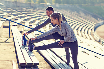 Image showing couple stretching leg on stands of stadium