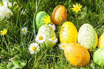 Image showing colored Easter eggs hidden in flowers and grass