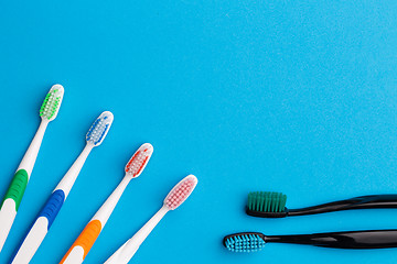 Image showing Four multicolored , two black toothbrushes