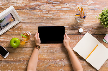 Image showing hands with tablet pc and notebook at office table