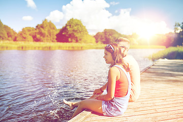 Image showing happy teenage couple sitting on river berth