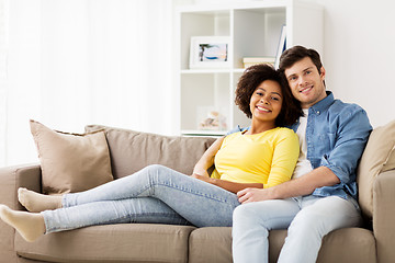 Image showing happy smiling international couple on sofa at home