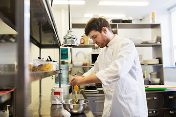 Image showing happy male chef cooking food at restaurant kitchen