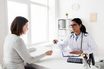 Image showing doctor with clipboard and woman patient at clinic