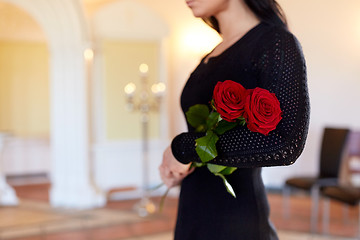 Image showing woman with red roses at funeral in church