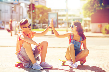 Image showing teenage couple with skateboards on city street