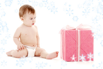 Image showing baby boy in diaper with big gift box and snowflakes