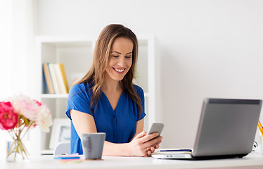 Image showing woman with smartphone and laptop at office