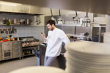 Image showing chef cook with smartphone at restaurant kitchen