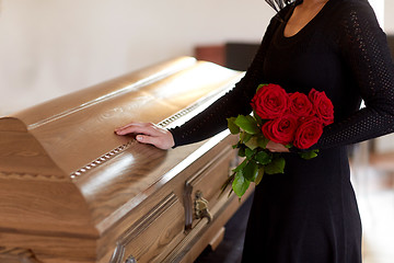 Image showing woman with red roses and coffin at funeral