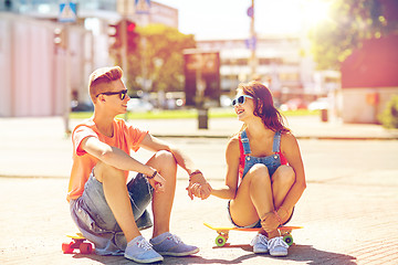 Image showing teenage couple with skateboards on city street