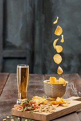 Image showing Beer glass and potato chips, pistachios isolated on a white